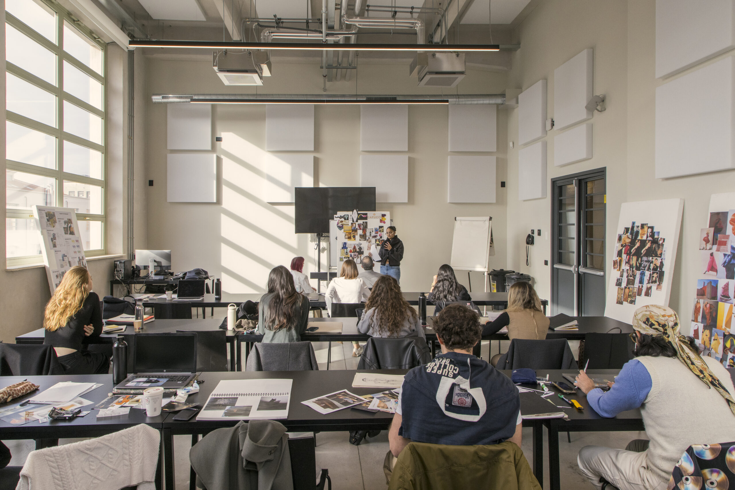 Students sit in a Creative Direction Master's class while one student presents their work. Should sustainable fashion be integrated into all aspects of fashion education?